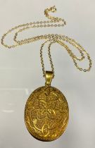 An 18ct gold oval locket, floral exterior, the interior with hairwork stripped panels, E J & S,