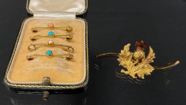 A Scottish Thistle bar brooch, orange citrine top, serpentine shaped bar, 9ct gold mounts, base