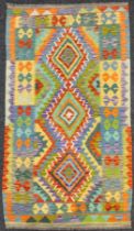 A Turkish Anatolian Kilim rug, knotted with a triple row of diamond-shaped medallions, within a