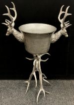 A large silver coloured metal ‘Stag’s head’ wine cooler/ice bucket, raised on a Stag Antler form