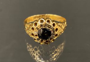 A diamond and garnet ring, deep red garnet surrounded by a collar of rose cut diamonds, 18ct gold
