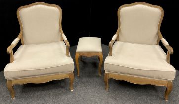 A pair of French Provincial style deep-seated elm armchairs, and a conforming footstool, the