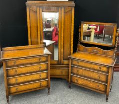 A mid 20th century oak bedroom suite, comprised of single wardrobe, chest of four drawers, and