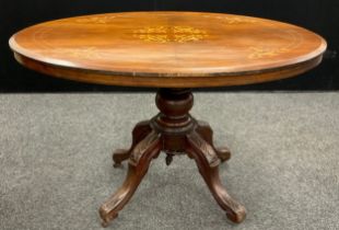 A late 19th century walnut veneered Loo table, tilting oval top with boxwood inlay, carved