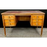 A French walnut writing desk, in the Louis XVI style, with inverted bow-front rectangular top, inset