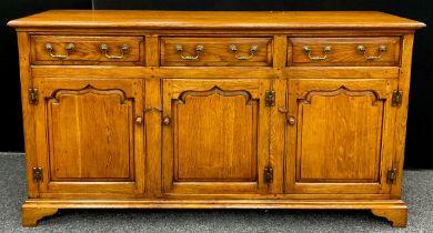 A Titchmarsh and Goodwin style oak dresser base, three short drawers to frieze, over three