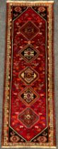 A South West Persian Qashqai runner carpet, hand-knotted in rich tones of red, black, blue, and