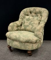 An early 20th century button back armchair, floral embroidered pattern, turned front legs fitted