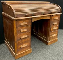 An early to mid 20th century oak roll-top desk, the tambour roll-top enclosing a fitted interior,
