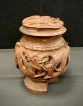 An Anglo Indian carved hardwood coconut shape tea caddy, carved with an interlocking band of