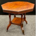 An Edwardian walnut octagonal occasional table, carved frieze, turned supports, with under-tier