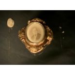 A Victorian lava cameo tie pin, oval portrait panel tip, unmarked spiralled shaft; mourning