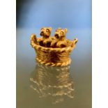 A novelty 9ct gold charm as two puppy's in a basket, Birmingham 1973, 3.1g