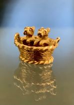 A novelty 9ct gold charm as two puppy's in a basket, Birmingham 1973, 3.1g