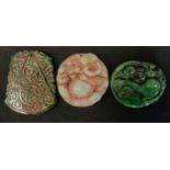 Three Chinese and Japanese tablet pendants, in multi tone green jade colours, as Hotei etc (3)