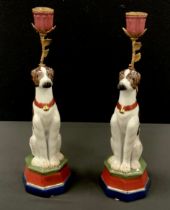 A pair of painted dog porcelain candlesticks, on octagonal plinth, printed mark to base, 34cm