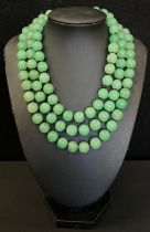 A string of green jade effect beads, 68cm long