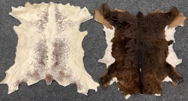 An Irish moiled calf hide, 93cm x 68cm another; cream and brown cow or calf hide, 90cm x 69cm (2).