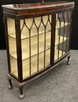 An Edwardian mahogany bow-front display cabinet, glazed doors and sides enclosing three tiers of
