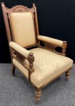 A Victorian walnut library armchair, carved top rail, upholstered back, arms, and seat, turned legs,