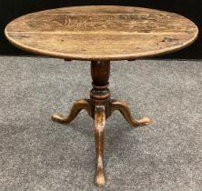 A George III oak table, circular plank top, turned column, tripod feet, 56cm high, 68cm diameter, (