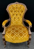 A Victorian walnut spoon-back armchair, deep-button upholstered back, carved scroll arms, turned