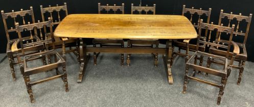 An Ercol Elm trestle dining table, 72.5cm high x 184cm x 81cm, and a set of eight ‘Old Colonial’