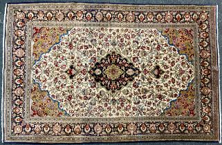 A Persian rug, central floral medallion, blue ground, within cream floral field, multi-layer border,