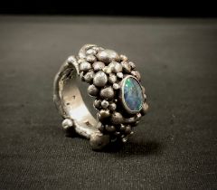 A modernist Michael Allen Bolton (Cornish) silver opal set ring, cast as a multi section rocky
