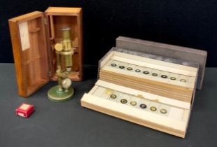An early 20th century brass travelling microscope, with mahogany case, and a large collection of