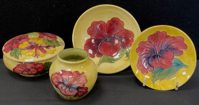 A Moorcroft pottery Hibiscus pattern trinket dish and cover, vase, bowl and trinket tray, all with