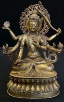 A Tibetan gilt bronze coloured metal Buddhistic figure, Bodhisattva seated, her six arms each