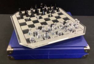 A Swarovski chess set - Black and clear cut crystal, mirror chess board in original case,