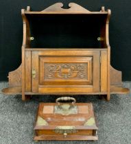 An early 20th century Arts and Crafts style oak wall cupboard, single shelf to top, above a small