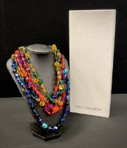 Erickson Beamon - a three strand multicoloured glass bead necklace, in tones of blue, red, pink,