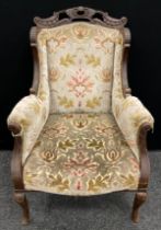 A Victorian carved walnut ‘Chinoiserie’ style wing-back armchair, carved top rail, scroll arms,