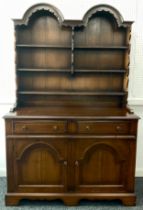 An oak double-arch-top dresser, plate rack top having three tiers of shelving, above two short