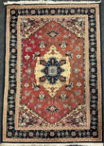 A Middle Eastern style wool rug / carpet, knotted with a central medallion within a field of