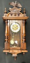 A Vienna wall clock, walnut and stained beech case, architectural cresting, brass dial with