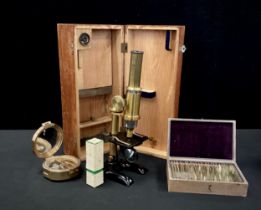 An early 20th century monocular microscope, with pine case; a box of approximately 25 prepared