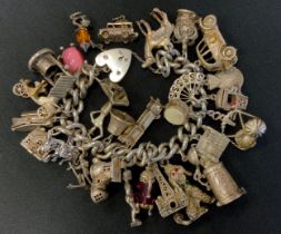 A large silver and white metal charm bracelet, suspending approx twenty five charms inc dancing