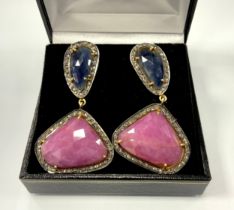 A pair of diamond and corundum earrings, each with a free form mixed cut sapphire and ruby