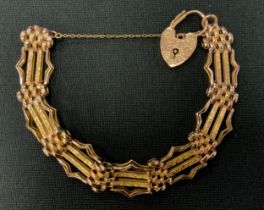 A 9ct gold fancy link gate bracelet, padlock clasp,. 1.4cm wide, 15.2g