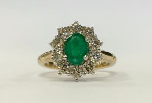 An Emerald and diamond cluster ring, central oval mid green emerald approx 0.85ct, surrounded by a