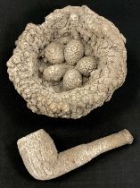 A petrified/calcified birds net, with five eggs, 12.5cm wide; similar pipe (2)