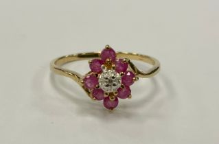 A ruby and diamond cluster ring, central diamond approx 0.02ct, surrounded by eight pink rubies,
