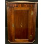 A George III oak corner cupboard, inlaid shell patera to the panelled door, enclosing three tiers of