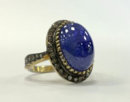 A tanzanite and diamond cabochon ring, central tanzanite oval cabochon approx 7.20ct surrounded by