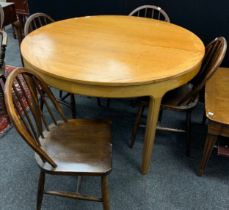 A Nathan Furniture extending dining table, 75cm high x 122cm diameter; with a set of four mid 20th