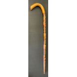 A 1930s Mexican walking stick, carved and painted with the Mexican coat of arms above bull